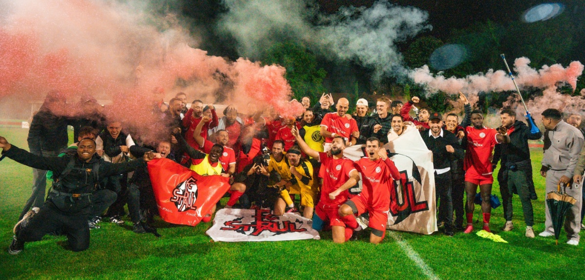Les joueurs et supporters du FC Saint-Paul célèbrent ensemble sur le terrain